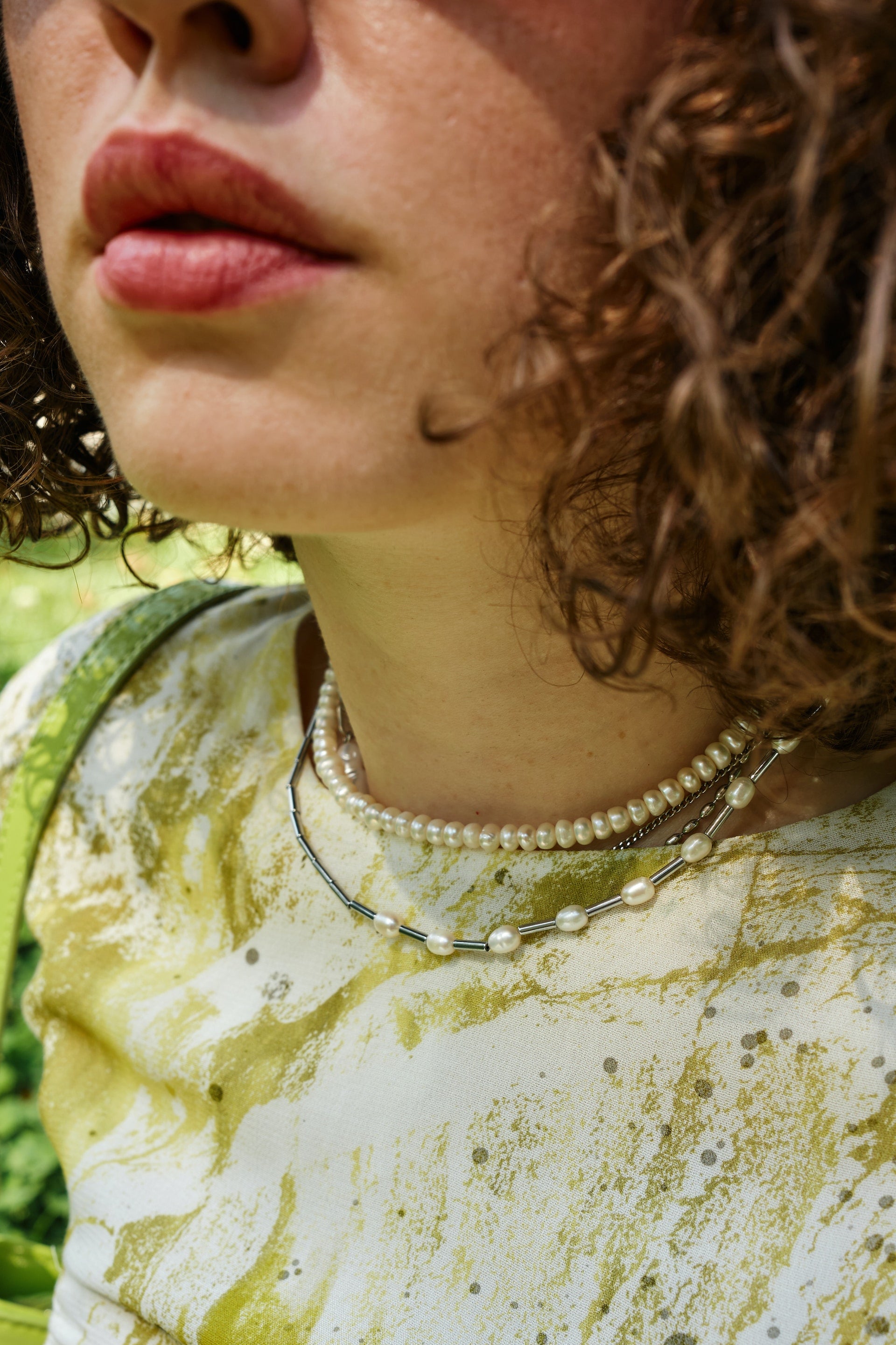 picture of a woman/girl with a lime tie die green shirt wearing a handmade pearl necklace